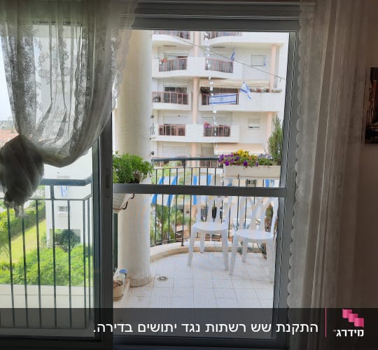 חלון אלומיניום עם וילון לבן ומרפסת